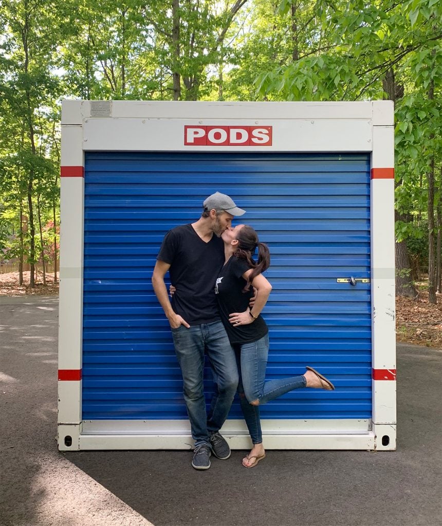 John and Sherry kissing in front of moving PODS storage container