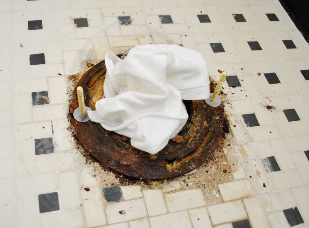 New Bolts On Toilet Flange With Rag In Sewer Hole