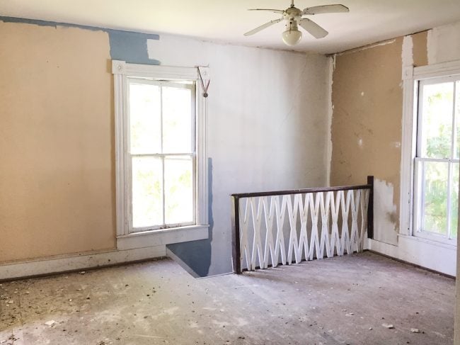 Before Photo Of Beach House Back Bedroom With Unpainted Walls and X Railing On Stairs