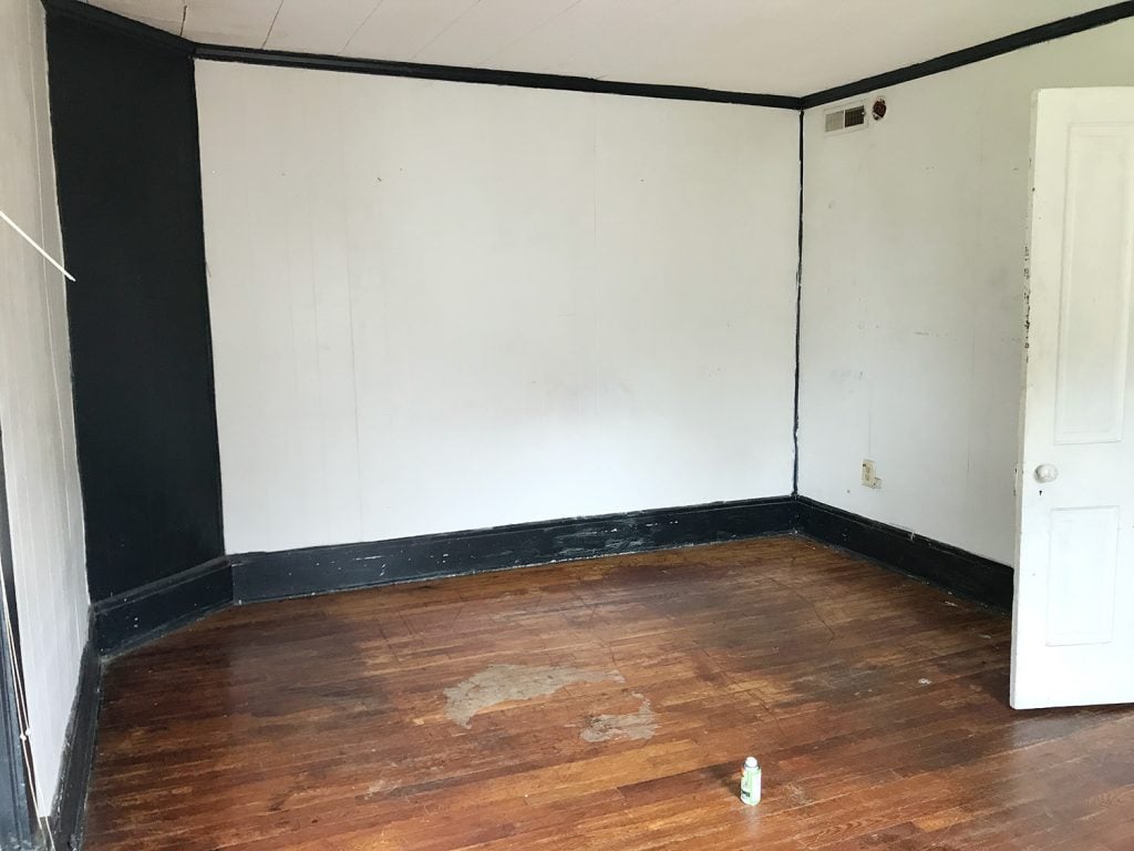 Before Photo Of Main Bedroom With Dark Green Trim Covering Corner Fireplace