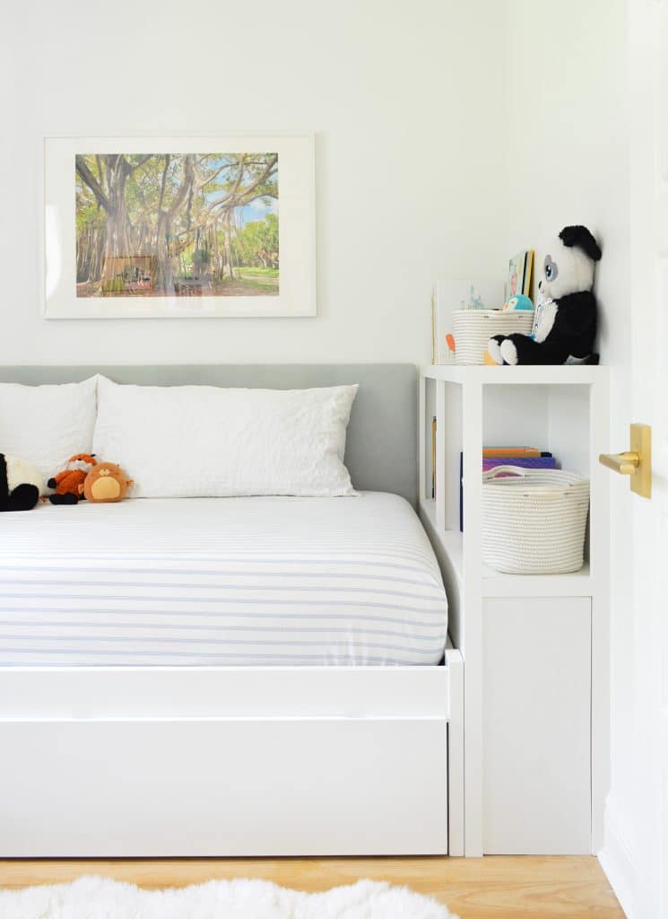 Boys bedroom with DIY fabric headboard and built-in bed with bookcase footboard