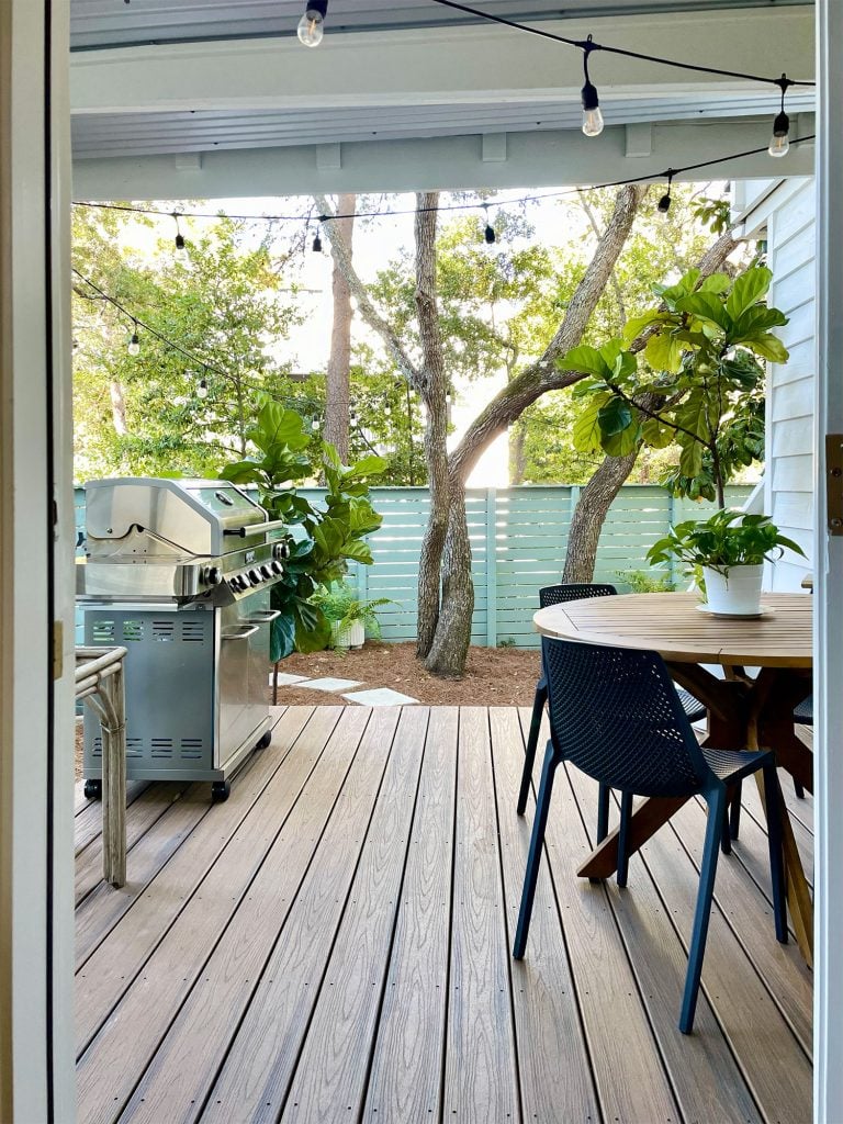 View through kitchen door of covered kitchen porch with table and grill